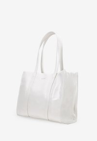 Bolso tote de cuero blanco con superficie lisa, asas dobles y acentos cosidos. Presenta un diseño espacioso y estructurado.