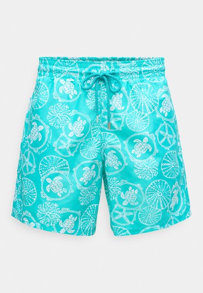 Turkoosi uima-shortsit, joissa on kevyt ja sileä kangas. Ominaisuuksina valkoisia kilpikonnia ja merieläinkuvioita, elastinen vyötärö ja nyöri.