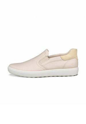 Zapato tipo slip-on en cuero beige suave con suela de goma blanca, con costuras mínimas y un sutil acento amarillo claro en el talón.