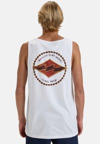 White tank top featuring a circular logo with a red and gold diamond shape and wave pattern. Text reads "Quality Surf Goods Since 1973."