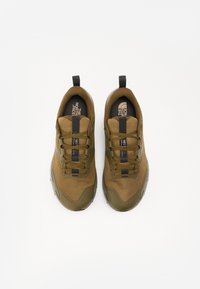 Olive green athletic shoes with mesh upper, black laces, and toe cap detail. Features a loop at the heel for easy wear.