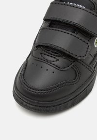 Must mustad nahkkingad Velcro rihmadega, ümar varvas, tekstureeritud pind ja tagasihoidlikud õmbluse detailid. Kummist tald, millel on sooniline muster.