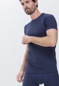 Marineblauw sport t-shirt met korte mouwen en blauwe accentstiksels, gemaakt van gladde, rekbare stof, snugly passend rond de borst en armen.