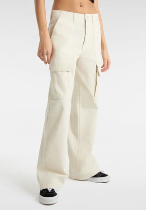 Pantaloni cargo a gamba larga in cotone crema, con tasche laterali e vestibilità rilassata. Abbinati a sneaker bianche e nere.