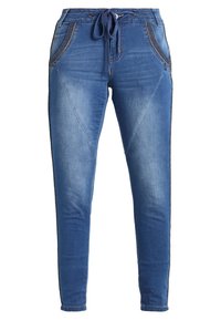 Modré denimové kalhoty ve stylu jogger s předními kapsami, pasem na stahování a upravenými švy po celé délce nohavic.