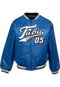 Blauwe satijnen bomberjack met witte en zwarte "Fubu League 05" logo. Geribbelde zwarte en witte manchetten, met zijzakken en een ritssluiting.