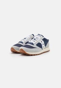 Baskets de course navy et grises avec des matériaux en maille et en daim. Lacets et accents blancs, semelle en caoutchouc gomme et design à bout rond.