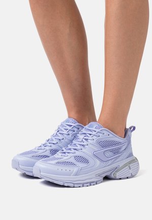 Lichtpaarse mesh en synthetische sneakers gedragen aan de voeten, met dikke zolen en een veterontwerp.