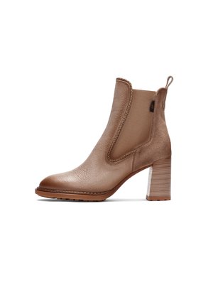 Bottine en cuir marron clair de hauteur moyenne avec talon bloc, panneau latéral élastique, languette de traction et semelle texturée, montrée de profil sur fond blanc.