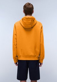 Orange hoodie with a drawstring hood, ribbed cuffs, and hem. Simple, plain fabric with a smooth texture. Paired with dark shorts.