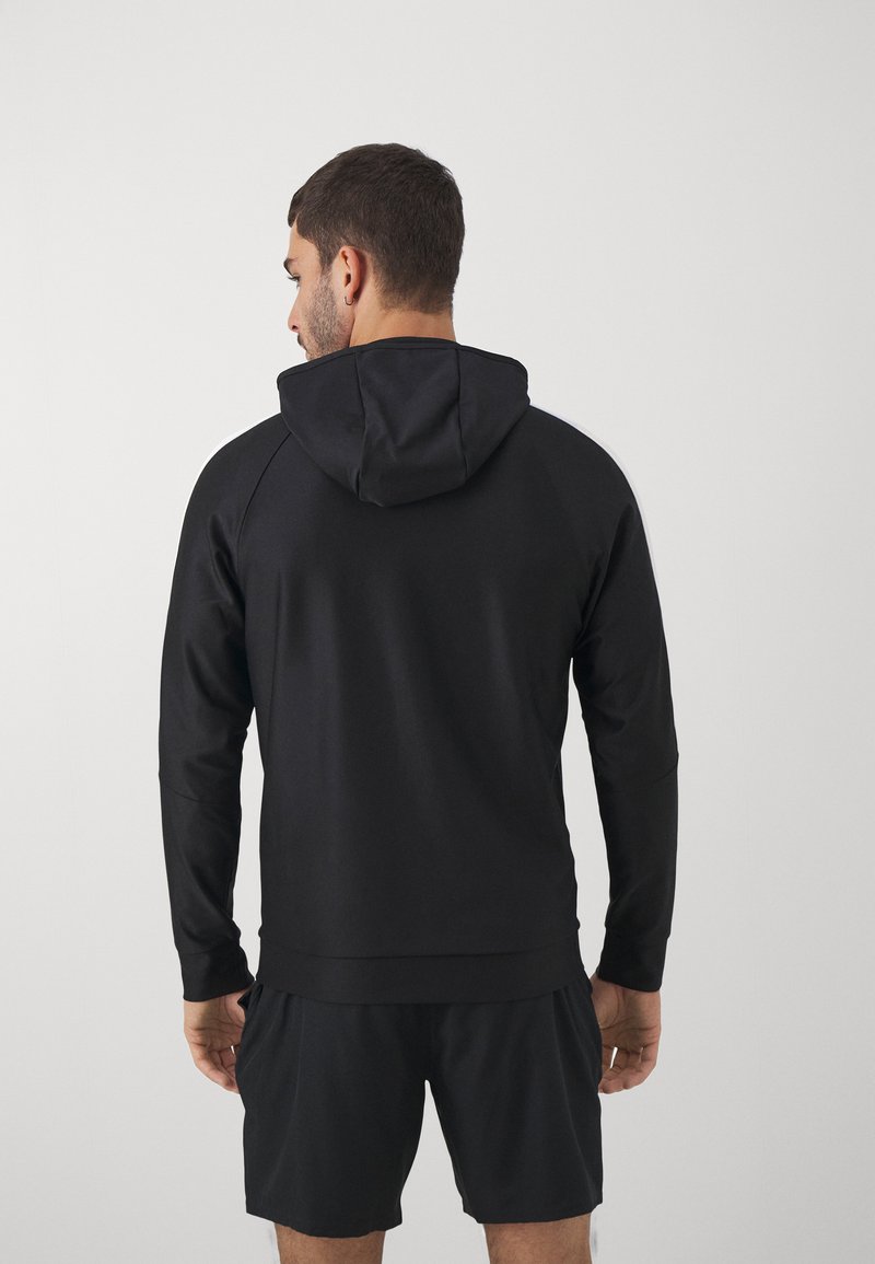 Schwarzer Kapuzenpullover mit langen Ärmeln, aus glattem Stoff gefertigt, mit einer lässigen Passform und geripptem Saum, kombiniert mit passenden Shorts.