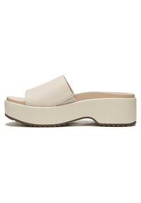 Beige platform slide sandals with a textured leather upper, wide strap, and a thick rubber sole featuring a zigzag tread pattern.