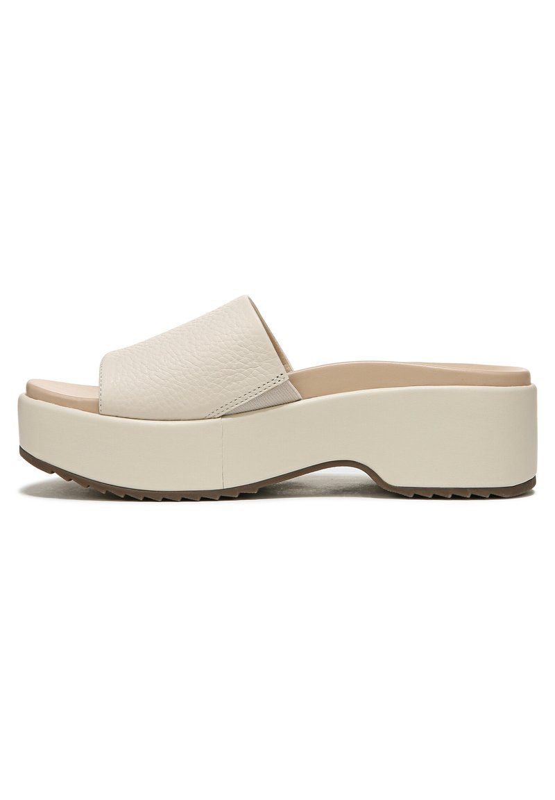 Beige platform slide sandals with a textured leather upper, wide strap, and a thick rubber sole featuring a zigzag tread pattern.