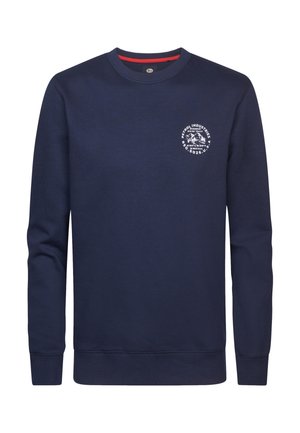 Tummansininen collegepaita, jossa on pitkät hihat, pyöreä kaula-aukko ja pieni pyöreä valkoinen logo rinnassa. Pehmeä tekstiili ja ribbaus hihansuissa.