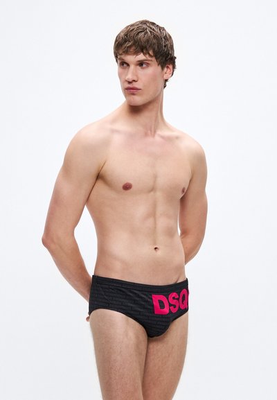Črne kopalne spodnjice s teksturiranim vzorcem in izrazitim rožnatim napisom "DSQ" na strani. Prilegajoč dizajn. Gladek, raztegljiv material.