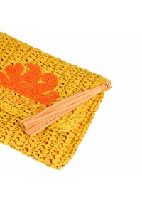 Bolso de mano tejido en color amarillo con un diseño floral en naranja. Cuenta con un tirador de cremallera en color melocotón con borlas y una superficie texturizada.
