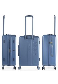 Maleta rígida en azul pizarra, que cuenta con doble cremallera, un mango retráctil y ruedas multidireccionales. Detalle del logotipo en relieve.