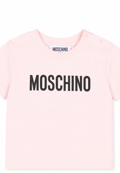 Maglietta rosa chiaro a maniche corte per neonati con la scritta nera "MOSCHINO" sul davanti e bottoni a pressione sulla spalla per facilitare la vestizione.