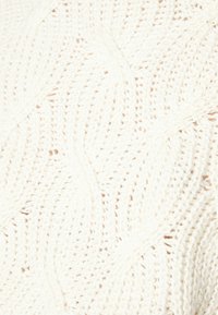 Knitted sweater fabric in cream with a wavy pattern, featuring a soft, textured appearance and lightweight, airy construction.