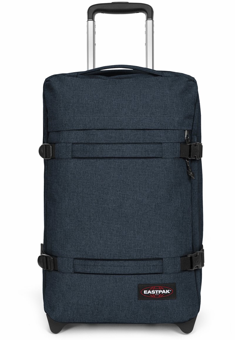 Rolling suitcase in dark navy fabric with a textured finish. Features a retractable handle, buckled straps, and a logo patch at the bottom.