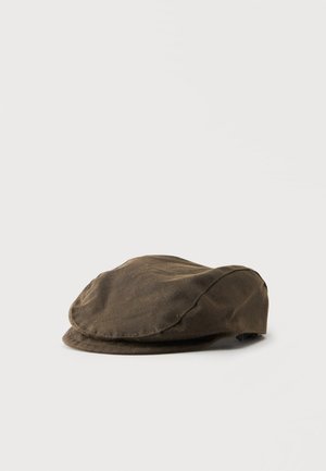 Casquette plate marron en tissu texturé, vue de profil sur un fond uni clair.