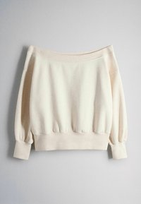 Roomkleurige, off-shoulder trui met lange mouwen en geribbelde manchetten en zoom, weergegeven op een effen lichtgrijze achtergrond.