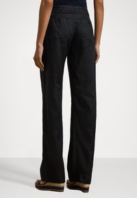 Zwarte linnen wijde broek met een trekkoord in de taille en achterzakken, met een soepele textuur en een relaxte pasvorm.