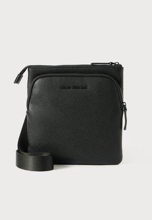 Sac en bandoulière en cuir noir avec une surface texturée, une poche zippée à l'avant et une sangle d'épaule plate et réglable.