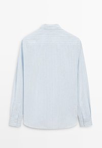 Chemise bleu clair à manches longues avec fines rayures blanches verticales, poignets boutonnés et col classique, vue de dos sur un fond blanc.