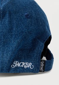 Μπλε σκούρο τζιν καπέλο μπέιζμπολ με κεντημένο λογότυπο "JACKER", υφή υφάσματος, ρυθμιζόμενο λουράκι και αντίθετη μαύρη ετικέτα στο πλάι.