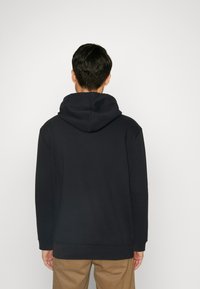 Navy hoodie with a drawstring, large hood, and ribbed cuffs. Made of soft fabric, featuring a relaxed fit and minimalistic design.