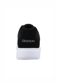 Baskets noires avec une tige en mesh et un panneau arrière solide, dotées d'un semelle intermédiaire blanche et du logo "Kappa" en blanc sur le talon.