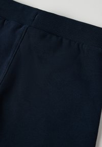 Marineblauwe rekstof heeft een geribde tailleband, een zachte textuur en platte naden, geschikt voor casual kleding of lichaamsbeweging.