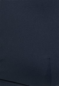 Tecido azul-marinho com uma textura canelada, exibindo linhas verticais subtis. O material parece durável e ligeiramente elástico.