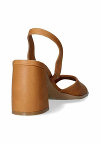 Sandalo con tacco a blocco di colore tan, con punta larga e arrotondata, apertura sul retro e cinturino regolabile. Materiale simile alla pelle, liscio.