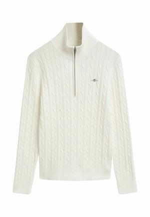 Maglione lavorato a maglia a trecce di colore crema con colletto alto, dotato di una chiusura frontale a mezza zip e polsi e orlo a costine. Logo sottile sul petto.