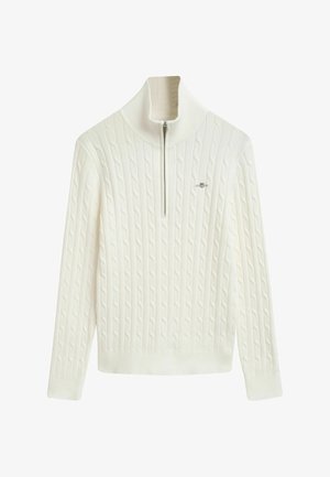 Cremefarbenes Kabelstrickpullover mit hohem Kragen, der einen halben Reißverschluss vorne hat, sowie gerippten Bündchen und Saum. Dezentes Logo auf der Brust.