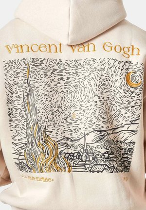 Beige hoodie met de naam Van Gogh en een geborduurd draaiend nachtelijk hemelpatroon, halve maan, vlammen en een dorp geïnspireerd op Sterrennacht.