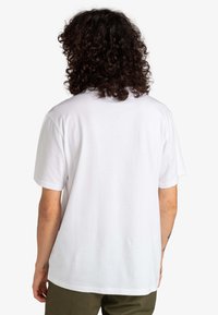 Biała bawełniana koszulka z krótkim rękawem, luźny krój oraz okrągły dekolt. Gładka tekstura bez widocznych wzorów czy grafik.