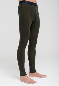 Oliven grønne termisk leggings med en tætsiddende pasform, der har et marineblåt elastisk liv og kontrasterende syninger langs sømmene.