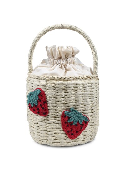 Cesta di paglia intrecciata con un cappuccio in tessuto beige a coulisse, con due fragole all'uncinetto rosse con accenti verdi all'esterno.