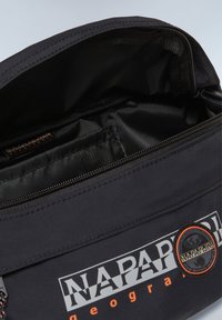 Bolsa de bolsillo negra con cierre de cremallera, que presenta un parche con el logotipo y un acento naranja. El interior está forrado con una tela suave y oscura para mayor durabilidad.