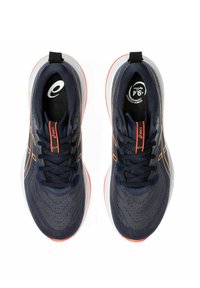 Baskets de course navy avec une tige en maille texturée, des accents orange et une semelle rembourrée. Elles disposent de lacets et d'une languette pour un enfilage facile.