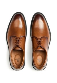 Bruine leren nette schoenen met een gladde afwerking, ronde neus, zes veterogen voor veters, en een gevoerde beige binnenzool. Zwarte rubberen zool.
