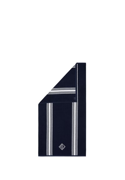 Serviette bleu marine avec des rayures blanches verticales et horizontales, pliée à un coin, présentant un petit logo en forme de losange près du centre inférieur.