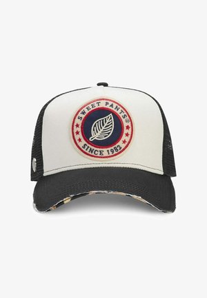 Casquette camionneur blanche et noire avec un écusson circulaire portant l'inscription "Sweet Pants Since 1982" et un motif de feuille au centre.