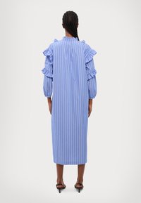 Blå och vit randig lång klänning med volangärmar, rak passform och längd till mitten av vaden. Slät tyg med en avslappnad känsla.