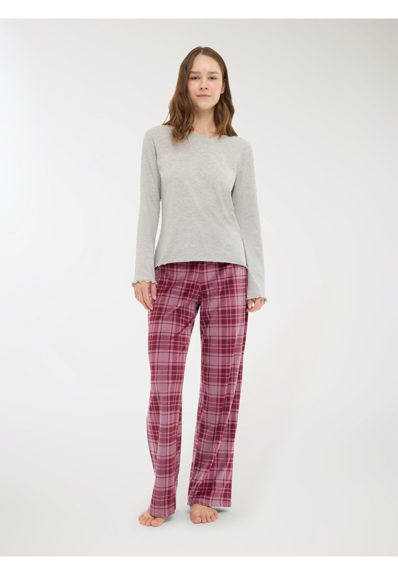 Maglietta grigia chiara a maniche lunghe con polsini a scallop, abbinata a pantaloni da pigiama larghi a quadri bordeaux con motivi intricati.