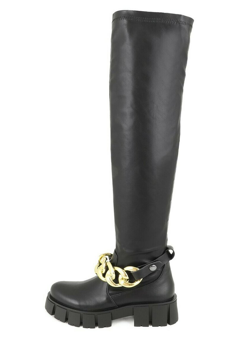Stivale in pelle nera alti fino alla coscia con suola nera spessa, caratterizzato da un grande accento di catena dorata attorno alla caviglia. Texture liscia e design minimale.