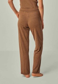 Braune, weiche Stoffhosen mit lockerer Passform und elastischem Bund. Die Textur ist glatt und sie haben einen geraden Beinansatz.